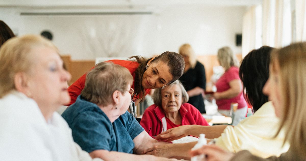 Caregiver engaging warmly with a group of seniors